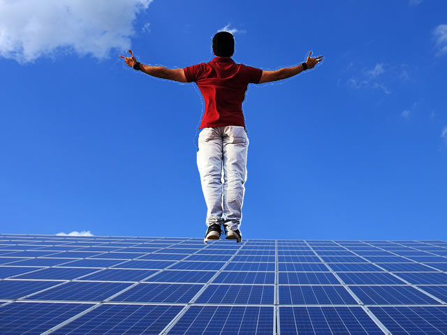 Image collage, Man is standing with arms outstretched against the sky on the edge of a solar panel